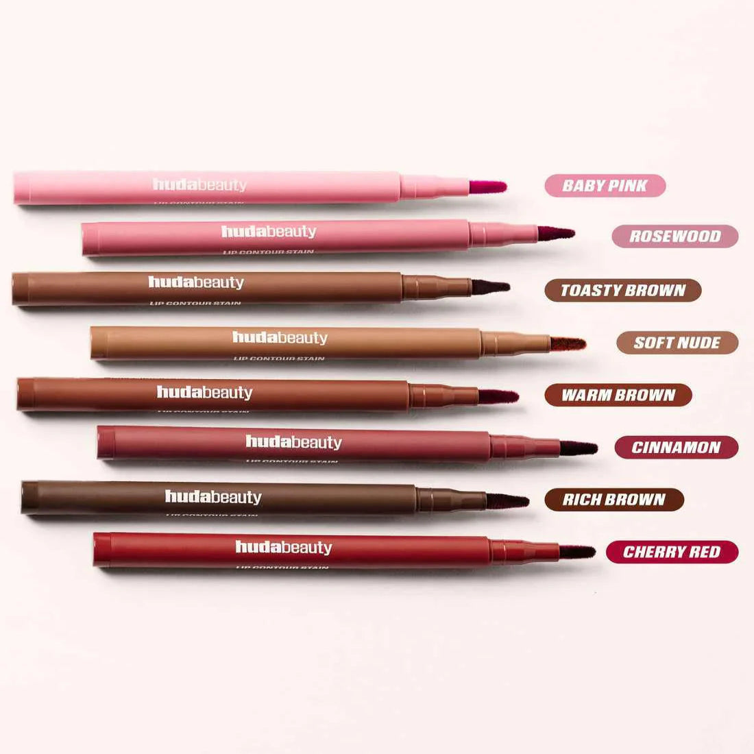 Set of Huda Beauty lip pencils in various colors on a white background
