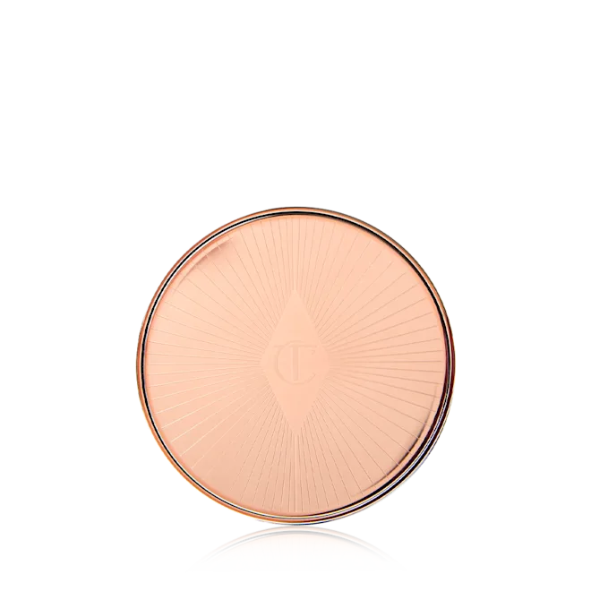 Round, rose gold compact on a white background