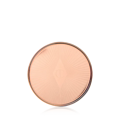 Round, rose gold compact on a white background