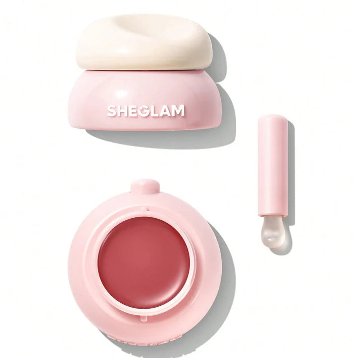 Pink cosmetic container with a lid and applicator on a white background, featuring the brand 'SHEGLAM'.