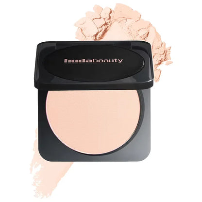 Huda Beauty compact powder with open lid showing product on a white background